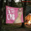 A pink tapestry with the text Welcome to my crib and a duck face design hanging between two trees.
