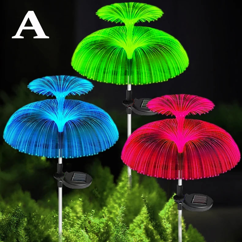 Three solar jellyfish garden lights in green, blue, and red illuminating a green foliage background.