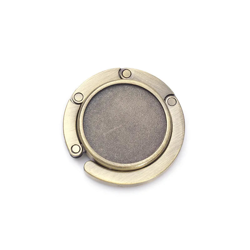 A round, brass-toned hook with a circular opening and four small holes for hanging.