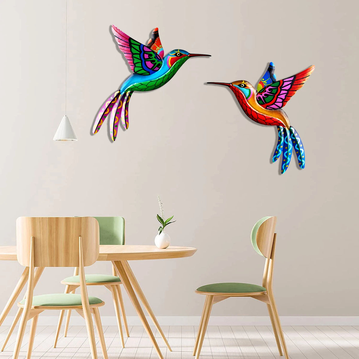 Vibrant metal hummingbird wall art featuring iridescent green, blue, and orange feathers on a light gray wall.