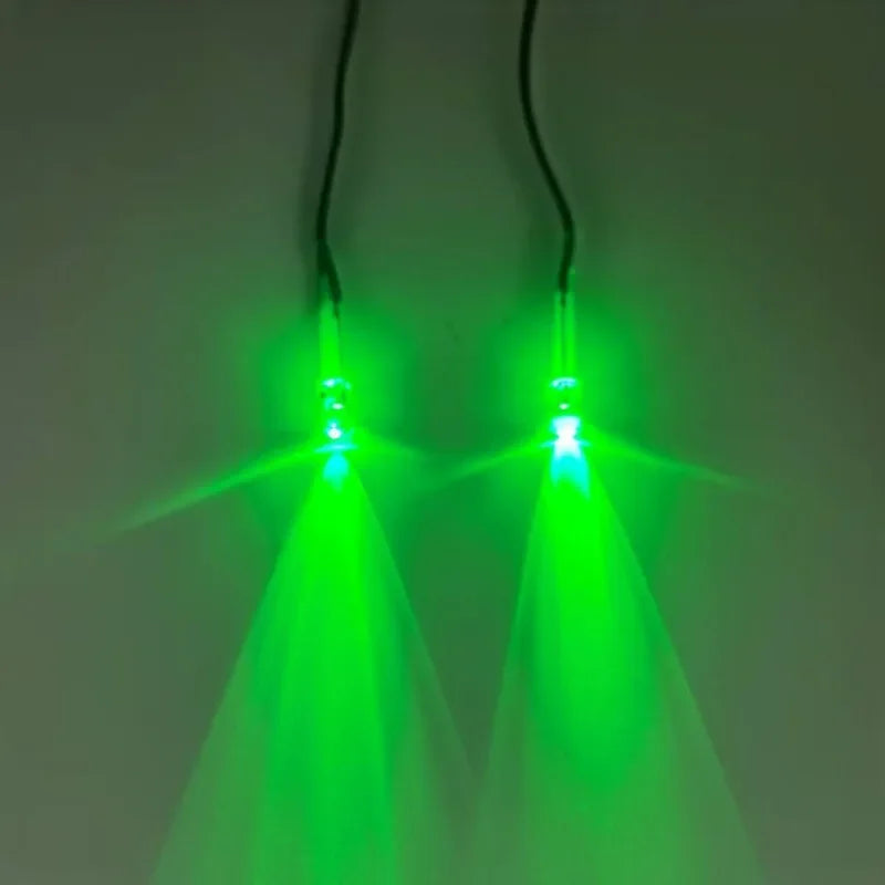 Pair of green LED glowing eyes illuminating a dark background.
