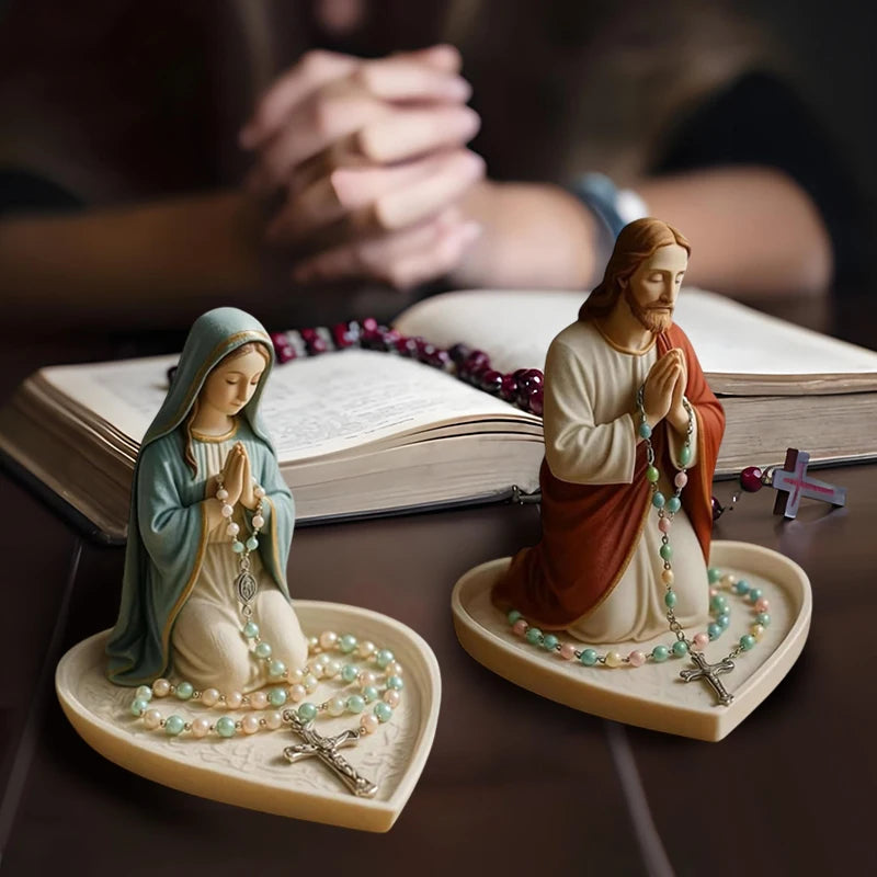 A statue of Jesus with a rosary and an elegant Virgin Mary figure on a tray.