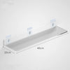 Clear acrylic floating shelf with wall mounts mounted on a white wall.