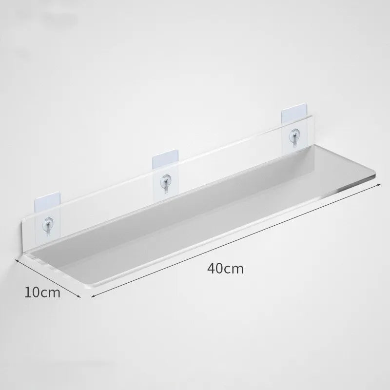Clear acrylic floating shelf with wall mounts mounted on a white wall.