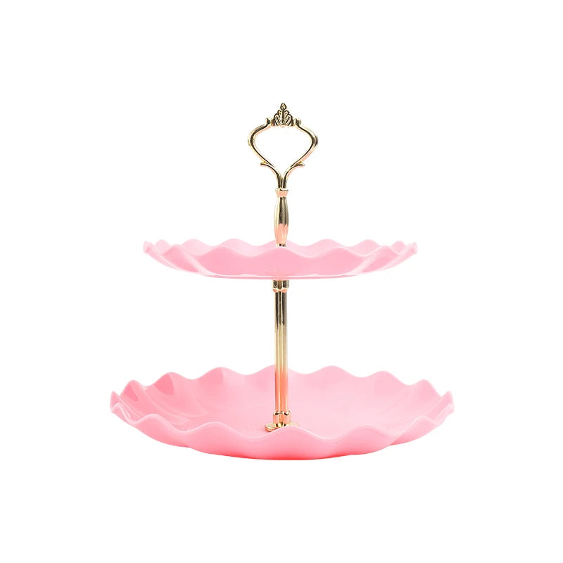 A two-tier serving stand with a gold-toned metal frame and pink ruffled ceramic plates.