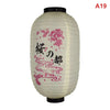 A white paper hanging lantern with pink floral designs and black top.