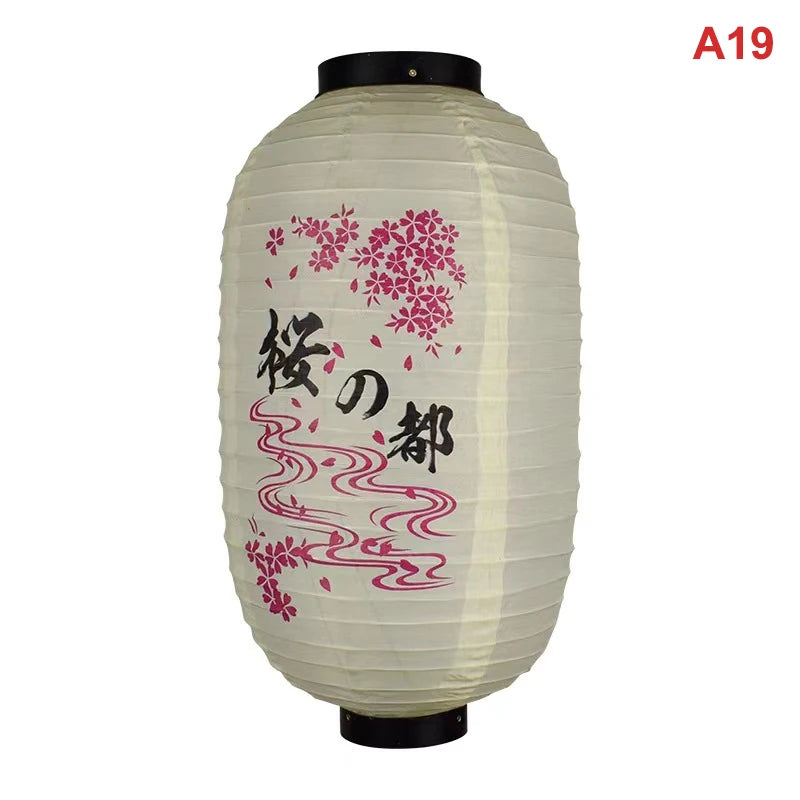 A white paper hanging lantern with pink floral designs and black top.