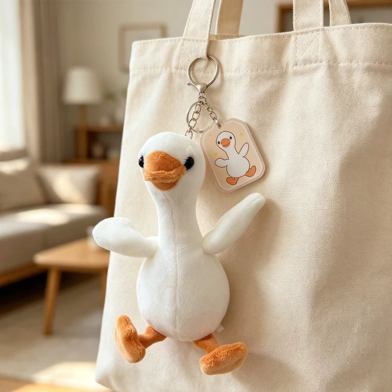 A white duck plush keychain pendant attached to a canvas tote bag.