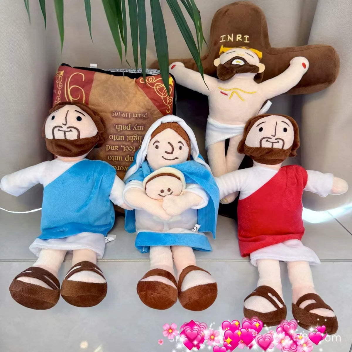 A plush doll set featuring Jesus and Mary figures in soft fabric with religious themes.