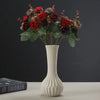 Artisan ceramic desktop vase with an organic ripple design filled with deep red and burgundy dried flowers
