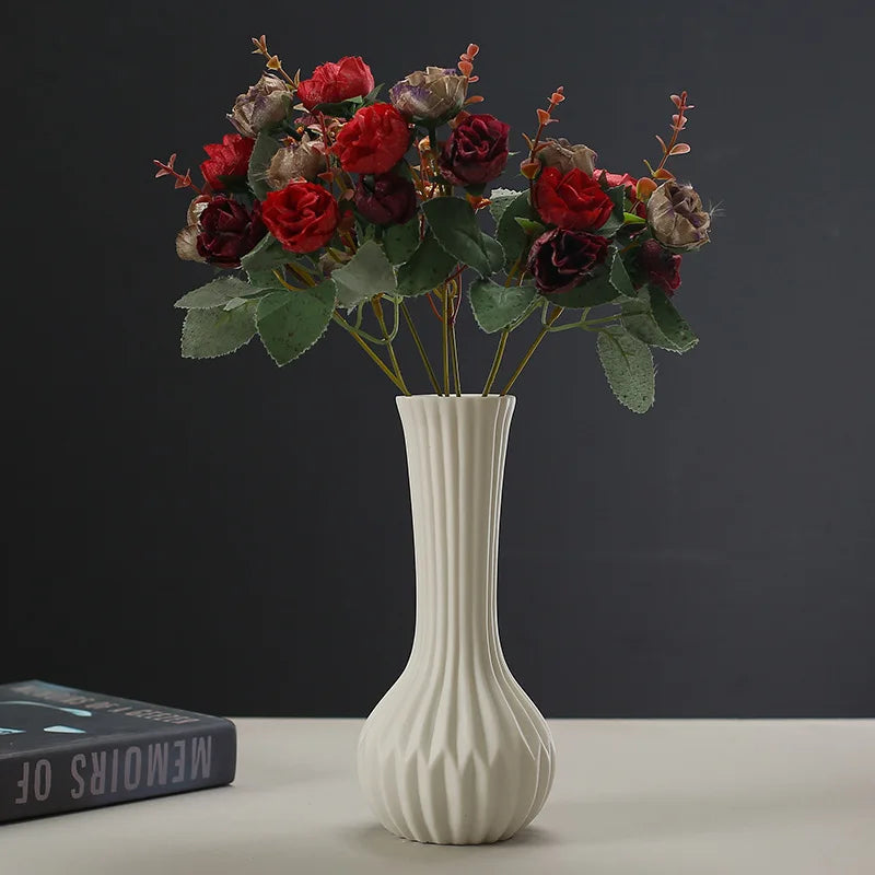 Artisan ceramic desktop vase with an organic ripple design filled with deep red and burgundy dried flowers