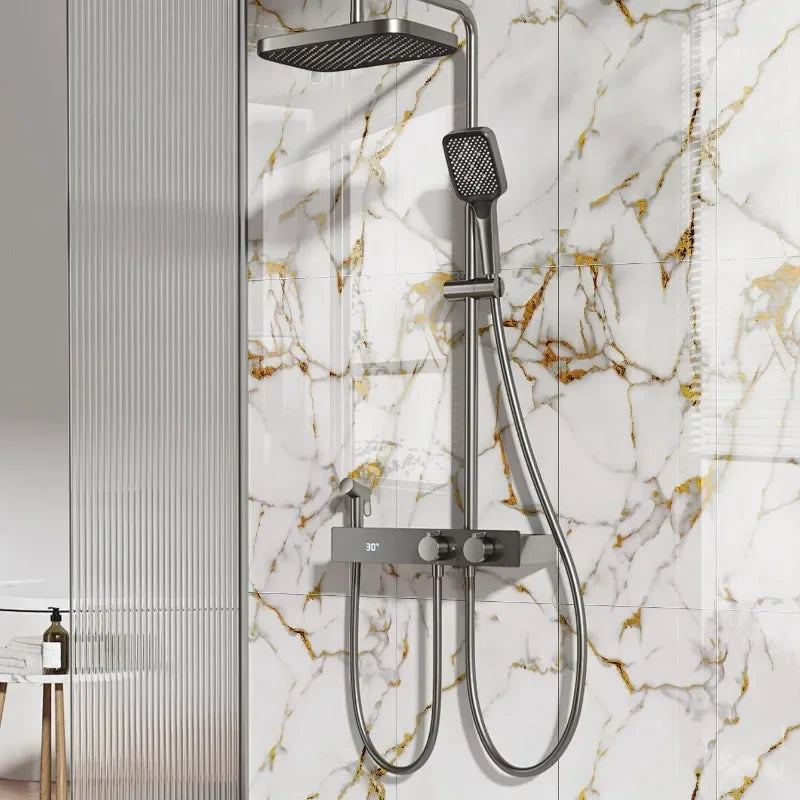 A silver shower head and hose fixture mounted on a white marble-patterned wall.
