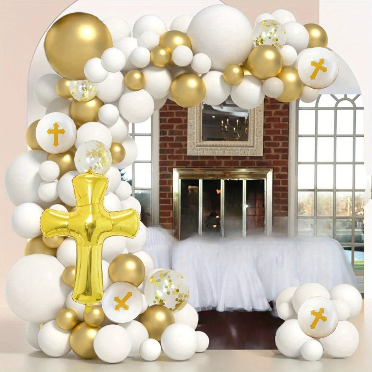 A balloon garland arch kit featuring white and gold balloons decorating a doorway with a brick background.