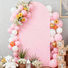 A pink arch cover decorated with balloons and flowers, featuring a large pink background.