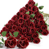 A dense bouquet of deep red artificial silk roses with green leaves.