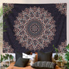 A dark tapestry wall hanging featuring a detailed mandala design in shades of pink and gray on a black background.