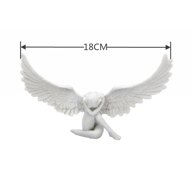 White resin angel wing figurine with a small figure in a praying pose, measuring 18cm.