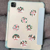 A clear phone case featuring multiple festive Christmas wreath stickers for decoration.