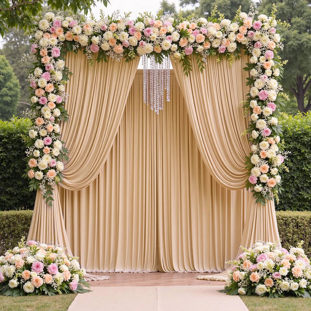 A beige satin backdrop curtain decorated with floral garlands and draped fabric for parties and photography.