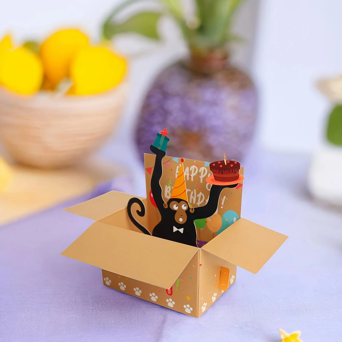 A humorous 3D pop-up birthday card featuring a monkey character with a party hat and heart balloons.