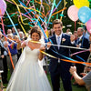 Braut und Bräutigam werden bei ihrer Hochzeit mit bunter Konfetti bespritzt.