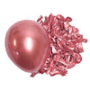 A single pink latex balloon next to a pile of crumpled deep burgundy latex balloons.