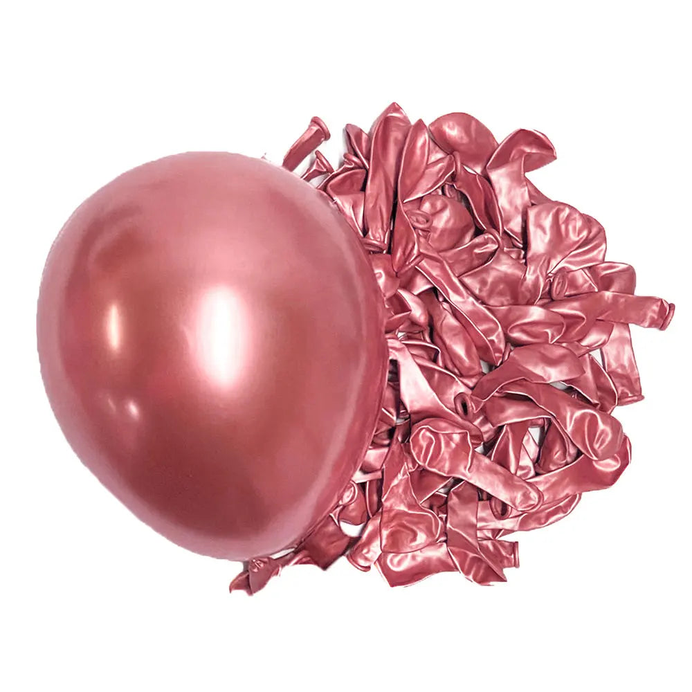A single pink latex balloon next to a pile of crumpled deep burgundy latex balloons.