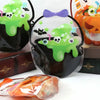 A clear plastic bag filled with green slime and a skull, used as a Halloween witch treat bag.