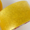 A close-up view of a yellow heavy-duty transparent packing tape roll.