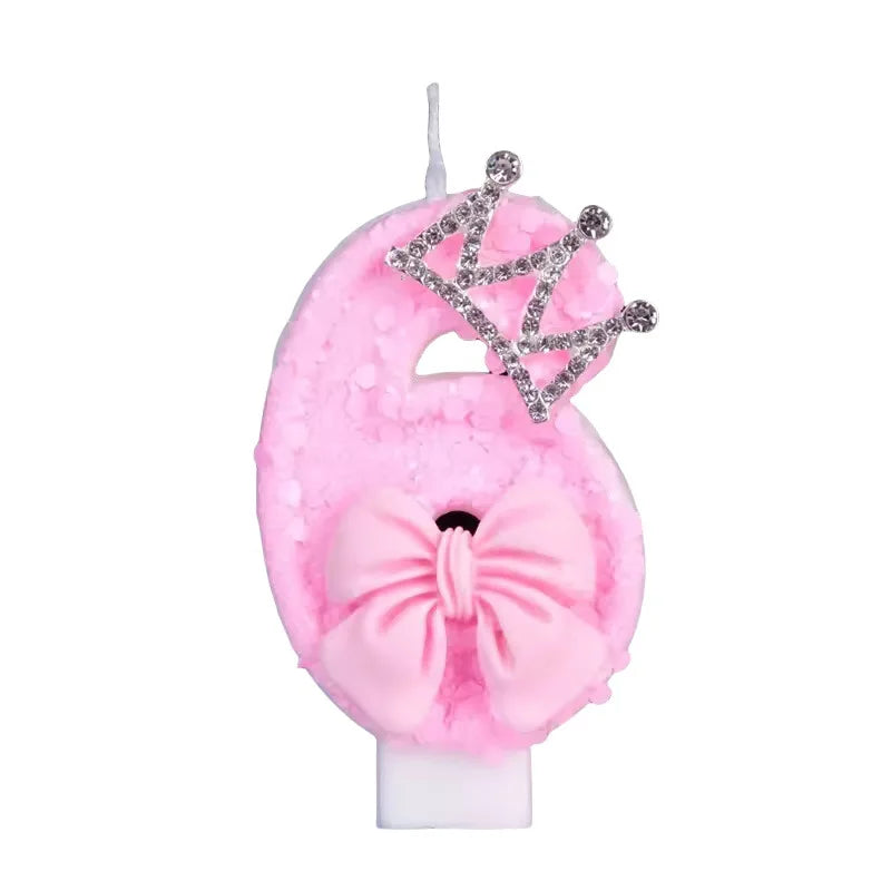 Pink felt candle shaped like a crown with a bow and a crown topper for a birthday cake.