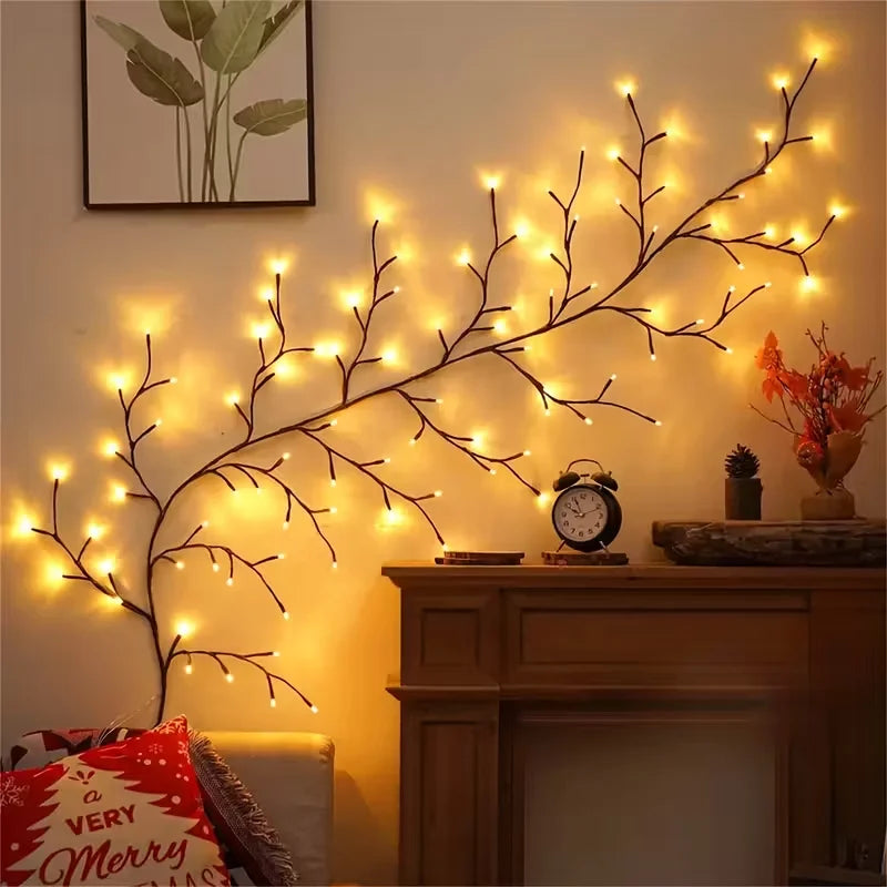 A branch of LED willow vine lights illuminates a wall, used for home decor.