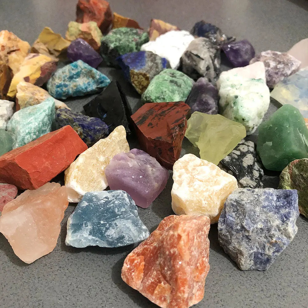 Assorted mixed natural raw crystal stones and healing minerals in various colors and shapes.