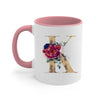 A pink ceramic coffee mug featuring a gold letter initial decorated with colorful flowers and greenery.