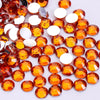 A collection of round, flatback resin rhinestones in various shades of orange and amber.