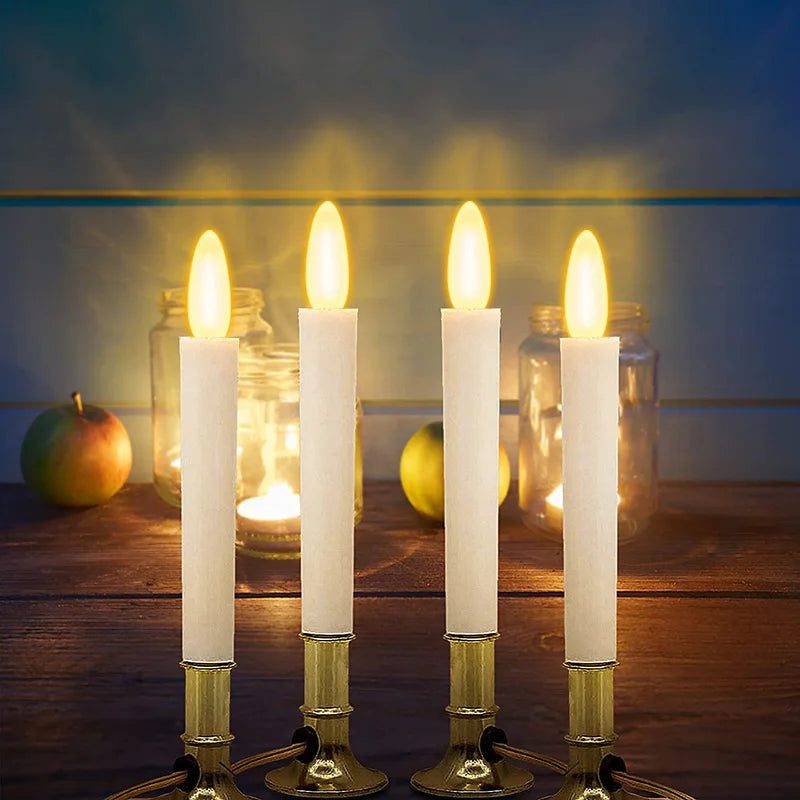 Four white pillar candles glowing in glass jars with warm light and golden illumination