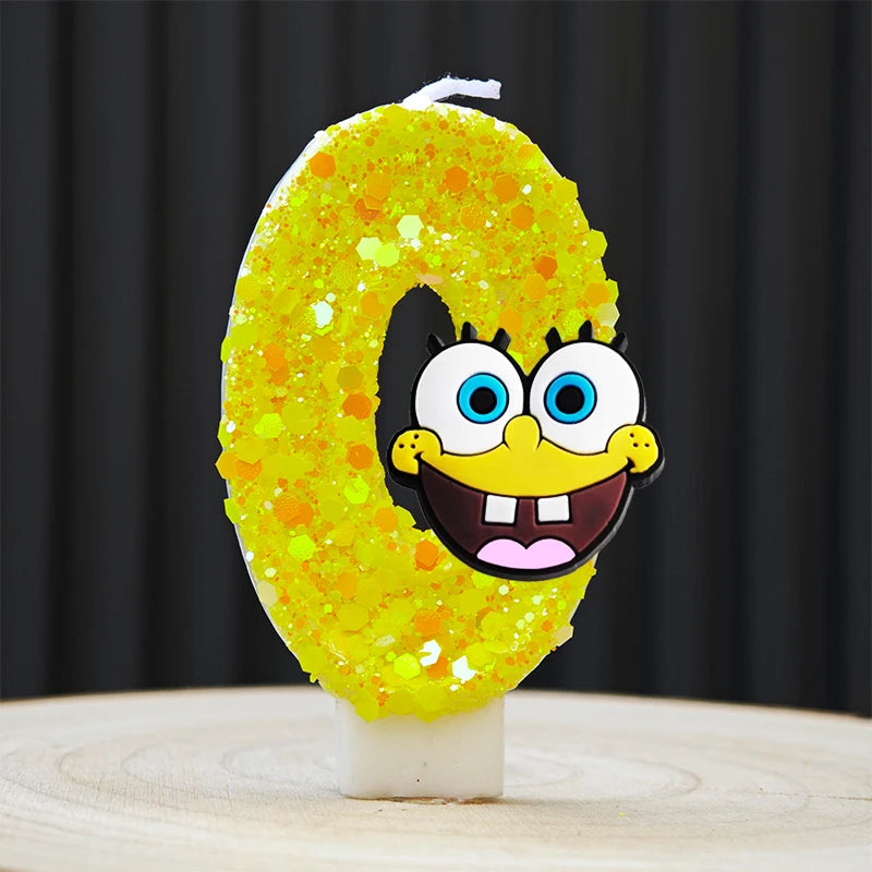 A yellow sponge cake candle shaped like the number 0, decorated with orange glitter and a SpongeBob face.