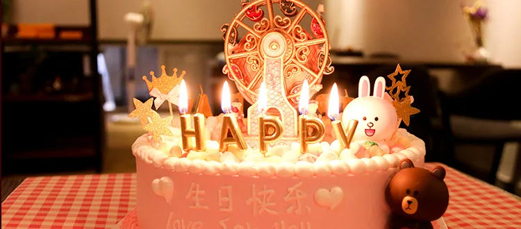 كعكة عيد ميلاد وردية مزينة بشموع مكتوب عليها HAPPYV وتماثيل أرنب أبيض.