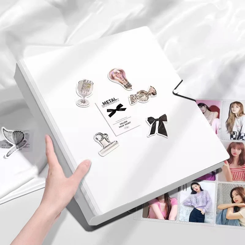 A white photo card binder with various metallic and decorative photo cards displayed inside.