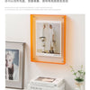 Moderner Acryl-Foto-Display-Rahmen mit einem hellen Kleidungsstück und Accessoires.
