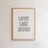 Framed wall art print with the text LOVE LIKE JESUS in black lettering on a white background and light wood frame