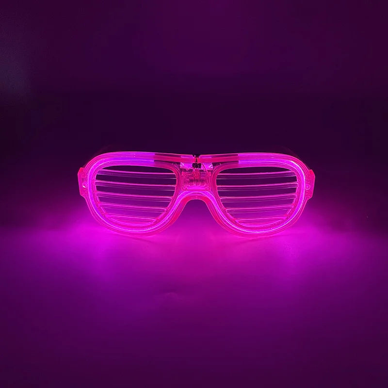 Pink leuchtende herzförmige LED-Partybrille leuchtet hell vor dunklem Hintergrund