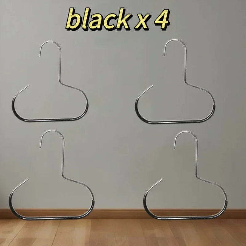 Four black metal hat organizer racks hanging on a white wall.