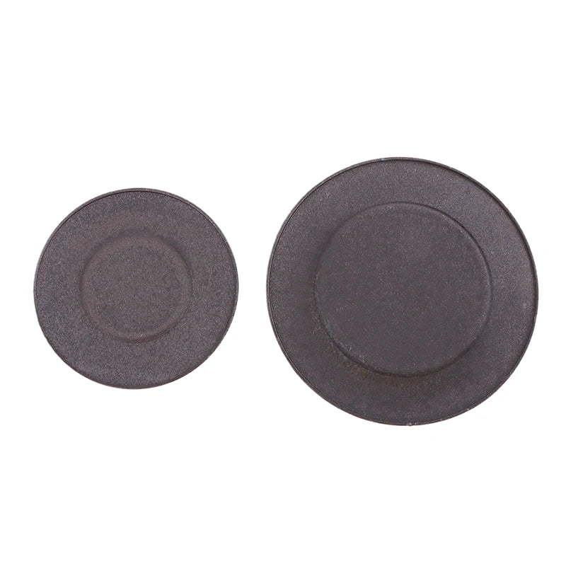 A pair of dark gray gas stove burner caps for efficient cooking.