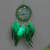 Handmade feather dreamcatcher wall decor with a green hoop and hanging teal feathers