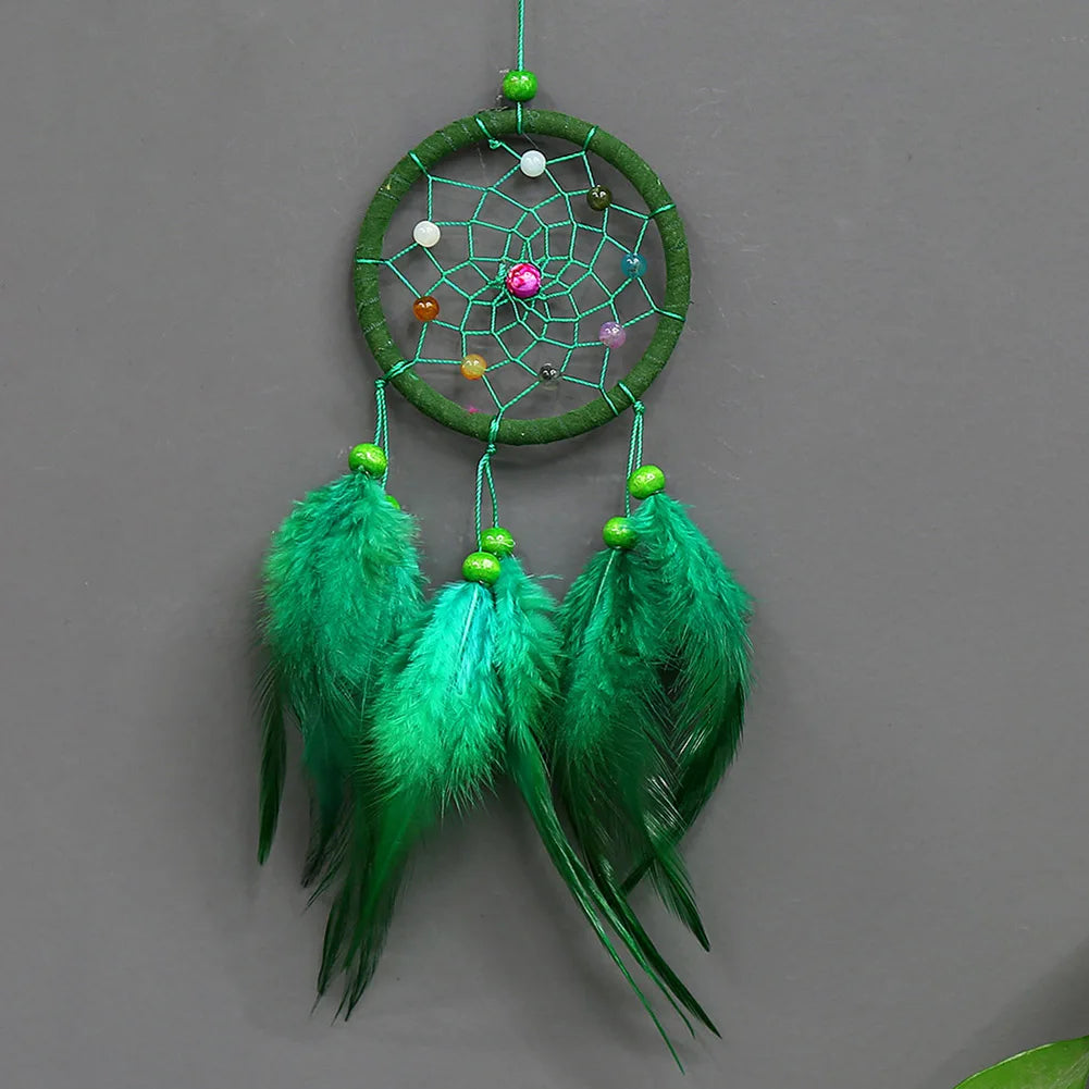 Handmade feather dreamcatcher wall decor with a green hoop and hanging teal feathers