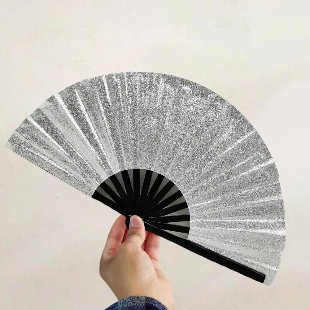 A hand is holding a glitter holographic fan, showing its radiating lines against a light background.