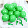 A collection of bright green latex balloons scattered on white fabric.