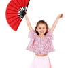 A young girl holding a red Tai Chi performance fan with black ribs against a white background.