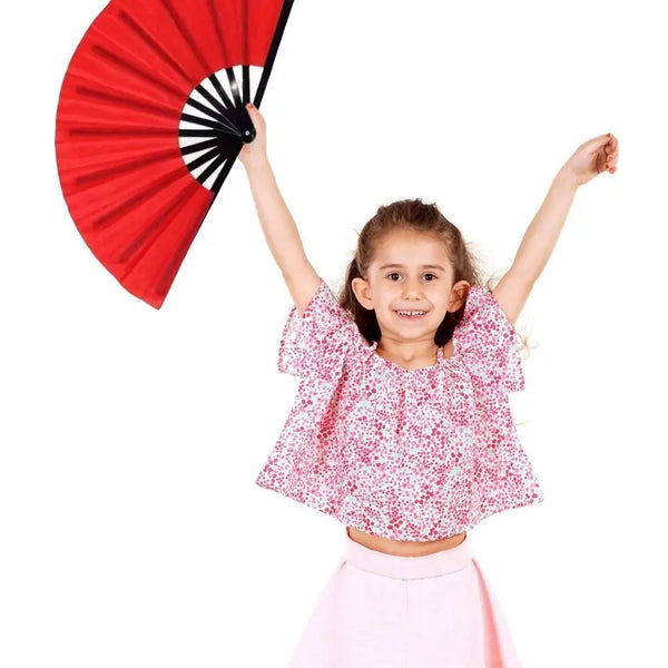 A young girl holding a red Tai Chi performance fan with black ribs against a white background.