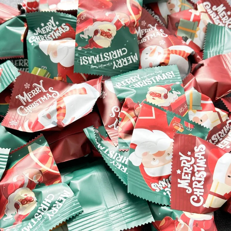 A pile of festive Santa Claus and snowman figurine sets for Christmas decor in various green, red, and white packaging.